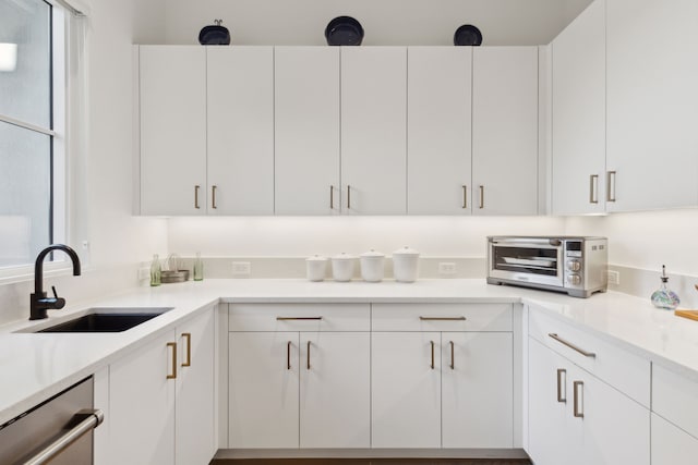 kitchen with sink, stainless steel dishwasher, and white cabinets