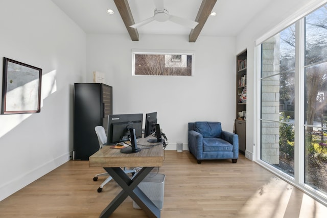 home office featuring beam ceiling, light hardwood / wood-style floors, and ceiling fan