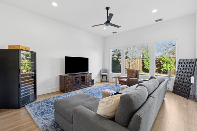 living room with ceiling fan and light hardwood / wood-style floors