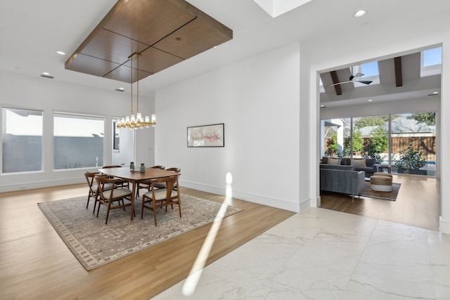 dining room featuring ceiling fan with notable chandelier and light wood-type flooring