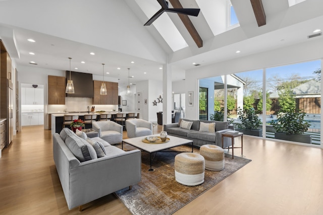 living room featuring beam ceiling, high vaulted ceiling, light hardwood / wood-style floors, and ceiling fan