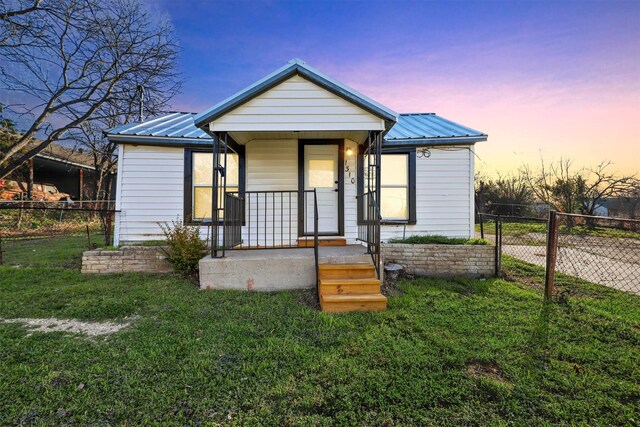 bungalow with a porch and a lawn