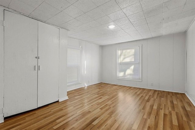 unfurnished bedroom with a closet and light hardwood / wood-style flooring