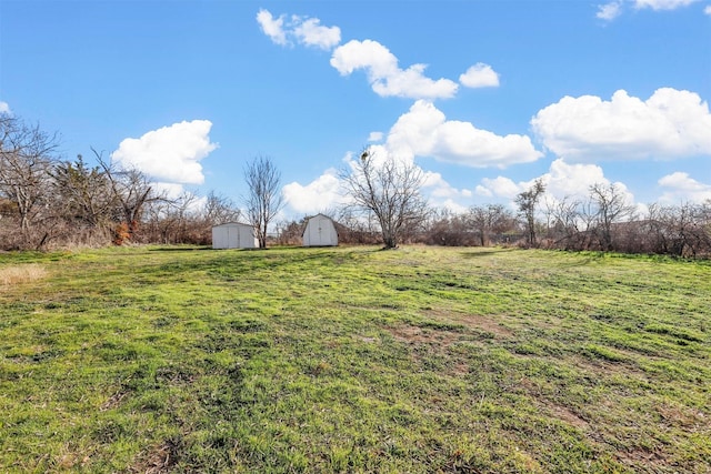 view of yard with a rural view and a storage shed