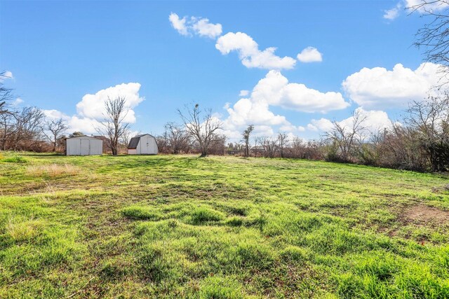 view of yard with a rural view and a shed