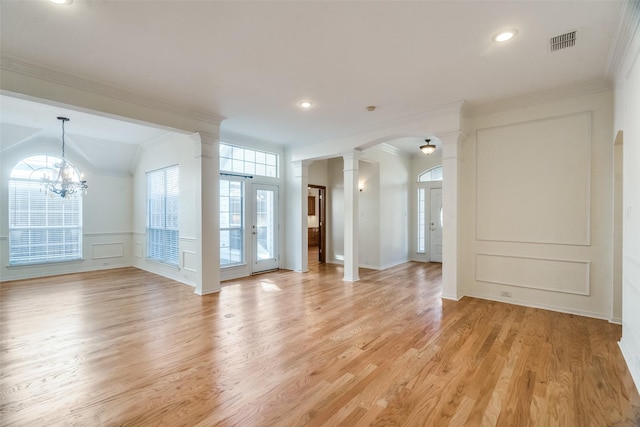 unfurnished room with vaulted ceiling, light hardwood / wood-style flooring, an inviting chandelier, and crown molding