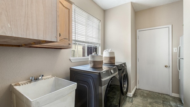 clothes washing area with cabinets, independent washer and dryer, and sink