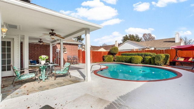 view of swimming pool featuring ceiling fan and a patio