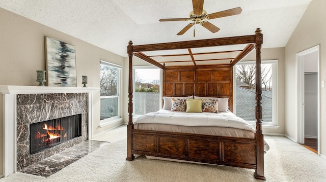 carpeted bedroom with ceiling fan, lofted ceiling, access to exterior, multiple windows, and a textured ceiling