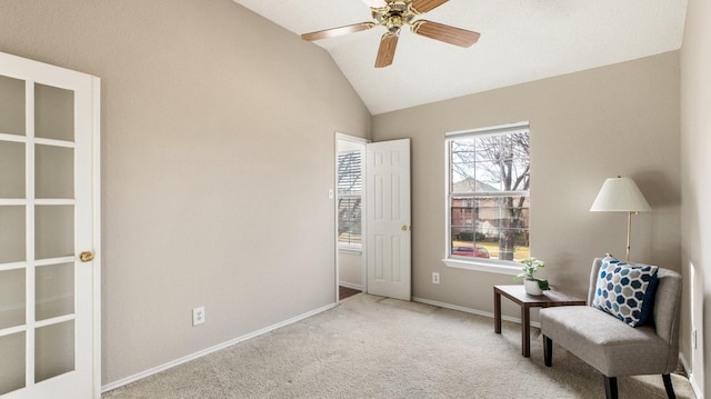 living area with ceiling fan, light colored carpet, and lofted ceiling