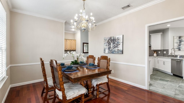 dining area featuring plenty of natural light, sink, ornamental molding, and an inviting chandelier