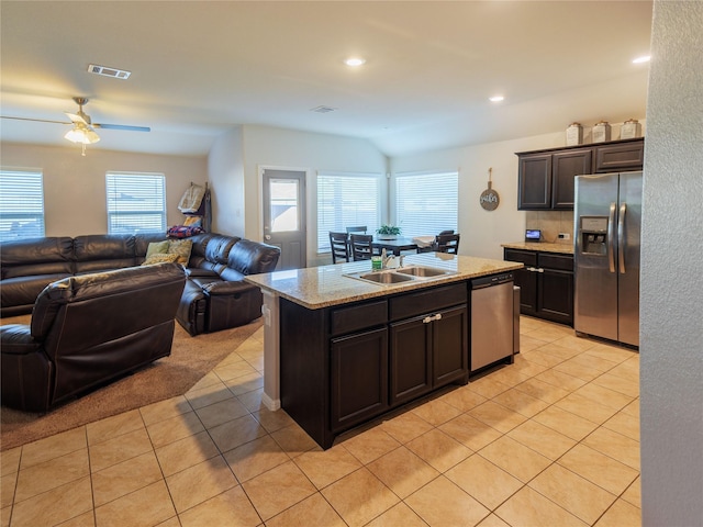 kitchen featuring a center island with sink, sink, ceiling fan, light tile patterned floors, and stainless steel appliances