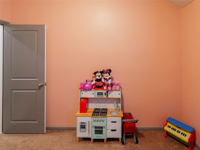 recreation room featuring light carpet