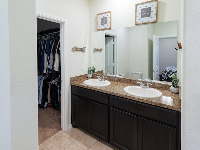 bathroom with tile patterned flooring, vanity, and toilet