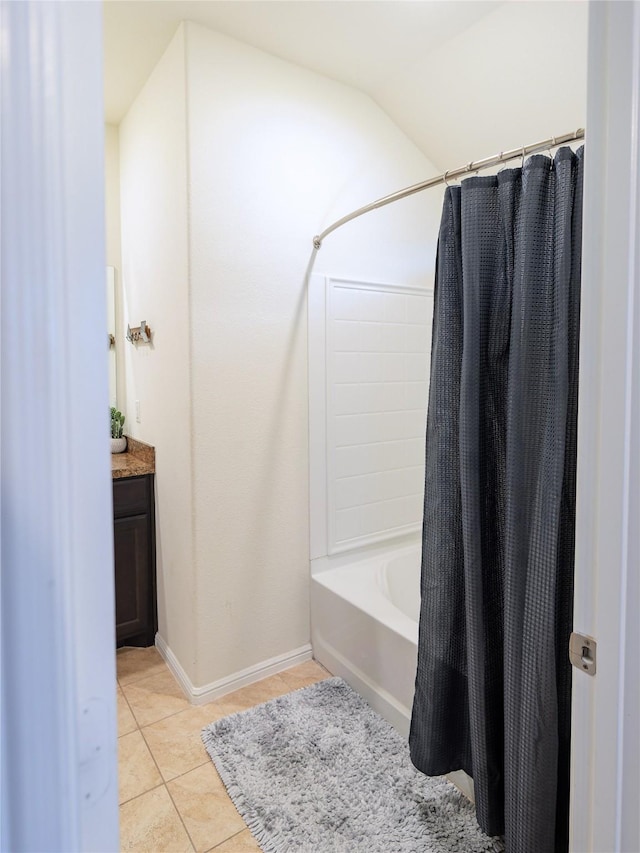 bathroom featuring shower / bath combo with shower curtain, tile patterned flooring, vanity, and lofted ceiling