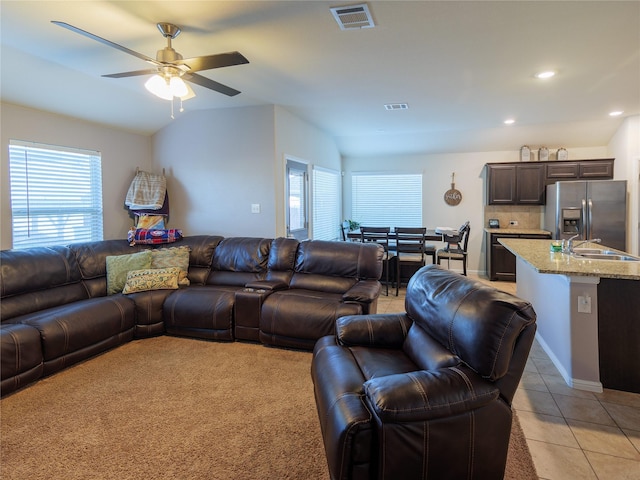 living room featuring light tile patterned floors, vaulted ceiling, ceiling fan, and sink