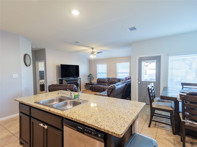 kitchen featuring ceiling fan, a kitchen island with sink, sink, light tile patterned floors, and dishwasher