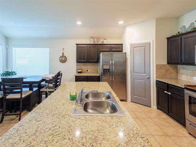 kitchen featuring dark brown cabinets, stainless steel appliances, tasteful backsplash, and sink