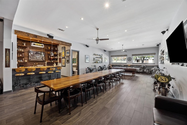 dining area featuring dark wood-type flooring and indoor bar