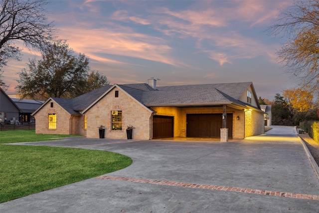 view of front facade with a yard and a garage