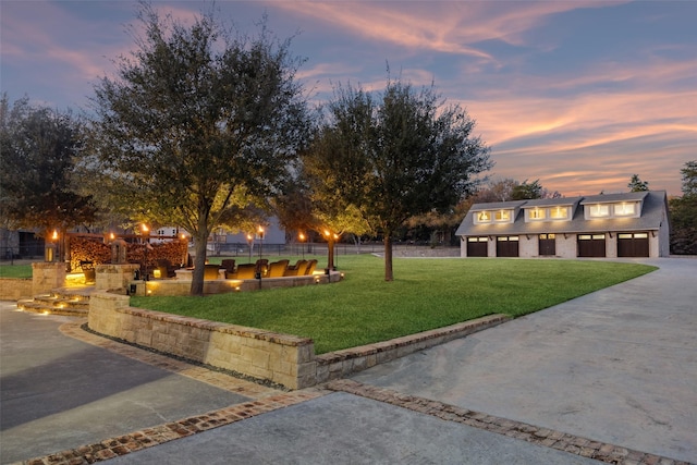 view of front of property featuring a garage, a lawn, and an outdoor structure