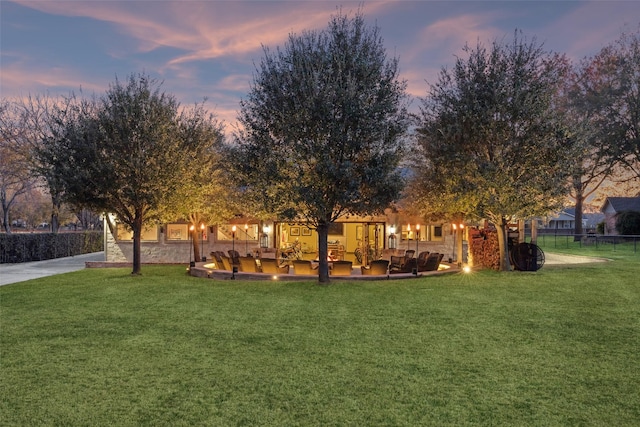 yard at dusk featuring a patio area