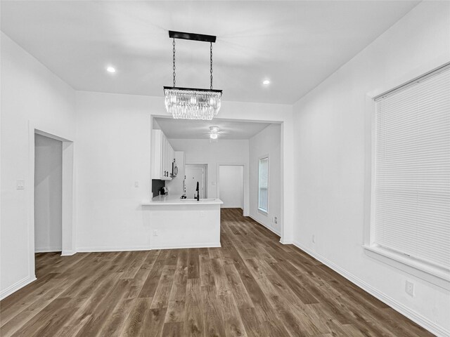 unfurnished living room with sink, dark hardwood / wood-style flooring, and an inviting chandelier