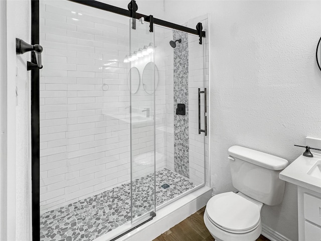 bathroom with hardwood / wood-style floors, toilet, and an enclosed shower