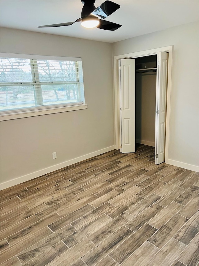 unfurnished bedroom with ceiling fan and a closet