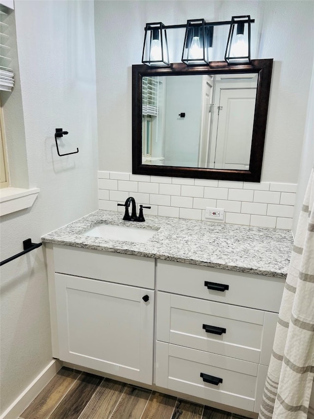 bathroom featuring backsplash, vanity, and hardwood / wood-style floors