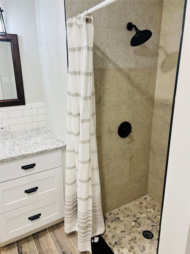 bathroom featuring a shower with shower curtain and backsplash