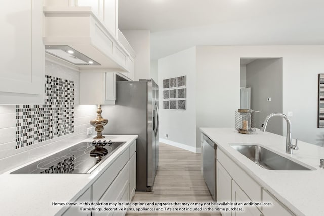 kitchen featuring black electric stovetop, backsplash, sink, dishwasher, and white cabinetry