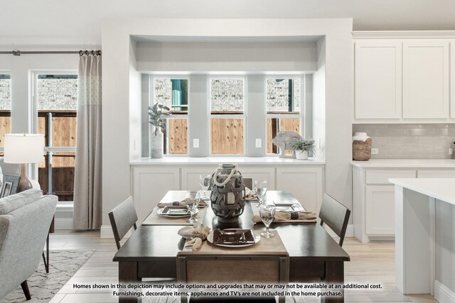 dining area featuring light wood-type flooring and a healthy amount of sunlight