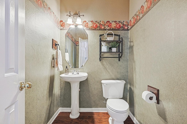 bathroom with hardwood / wood-style flooring, toilet, and sink