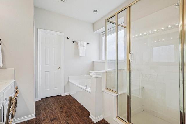 bathroom with hardwood / wood-style floors, vanity, and separate shower and tub