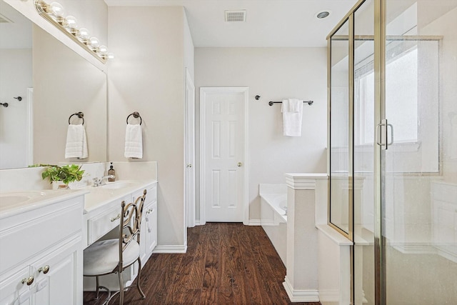 bathroom with independent shower and bath, vanity, and wood-type flooring