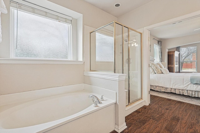 bathroom featuring hardwood / wood-style floors, a wealth of natural light, and independent shower and bath