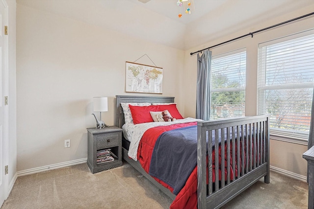 bedroom with carpet flooring, vaulted ceiling, and multiple windows