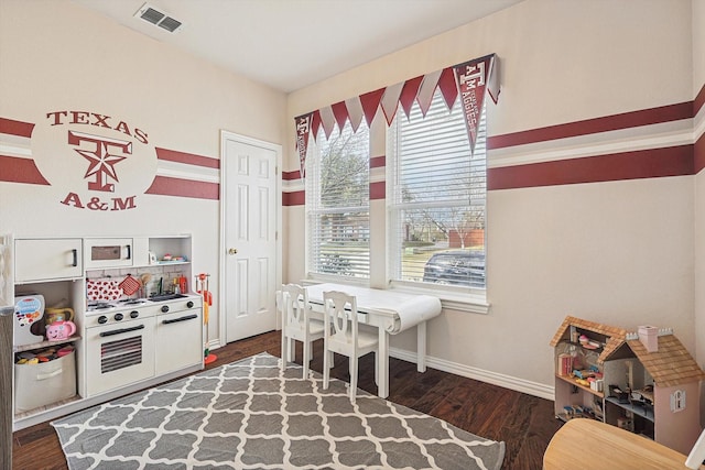 playroom with dark wood-type flooring