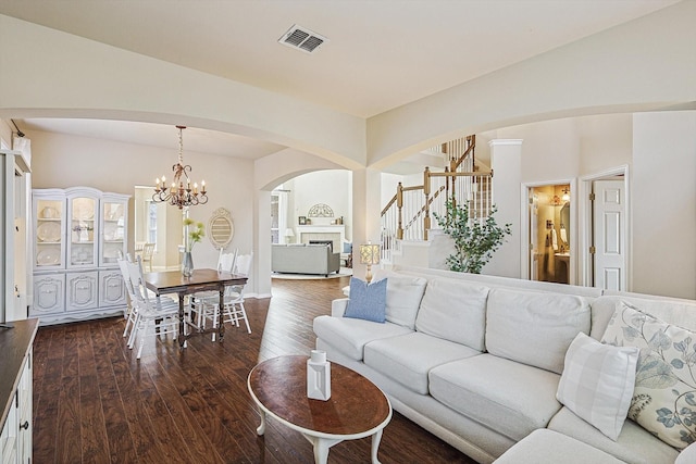 living room with dark wood-type flooring and a chandelier