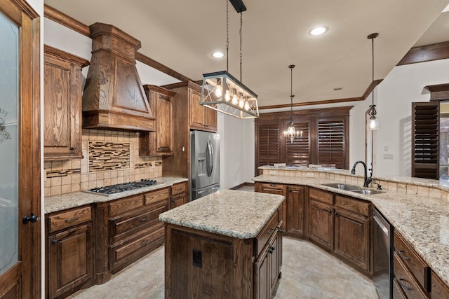 kitchen featuring sink, decorative light fixtures, a kitchen island, stainless steel appliances, and light stone countertops