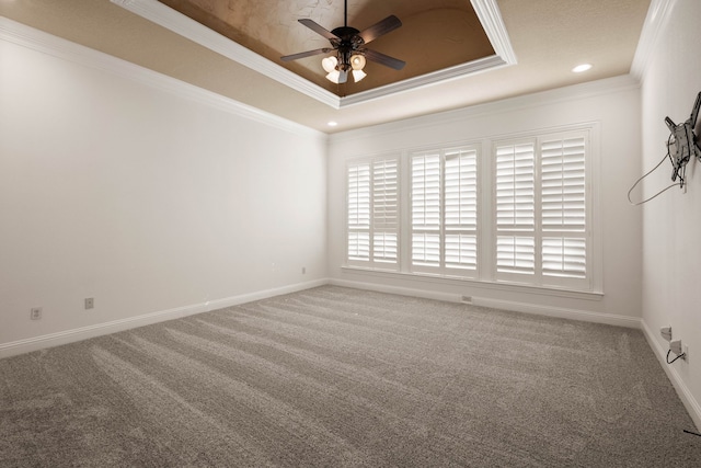 carpeted spare room featuring crown molding, ceiling fan, and a tray ceiling