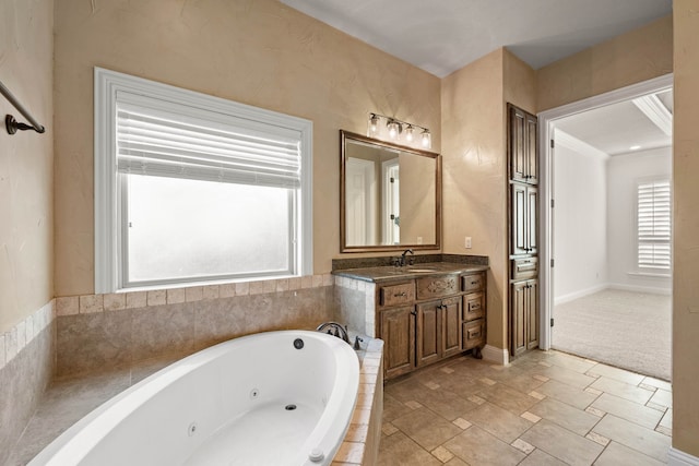 bathroom with ornamental molding, vanity, and tiled tub