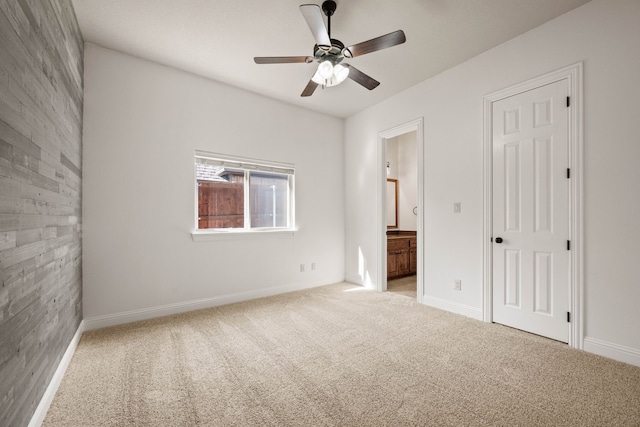 unfurnished bedroom with ceiling fan, light colored carpet, and ensuite bath