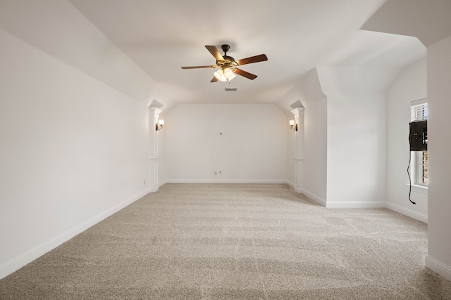 carpeted empty room with vaulted ceiling and ceiling fan