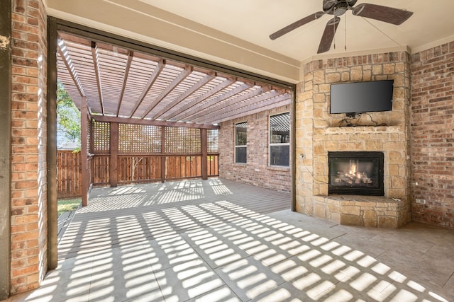 view of patio with ceiling fan, a pergola, and an outdoor stone fireplace