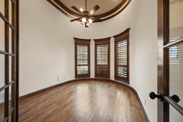 empty room with crown molding, wood-type flooring, french doors, and ceiling fan