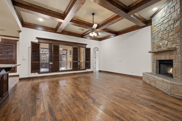 unfurnished living room with beamed ceiling, ceiling fan, coffered ceiling, and a fireplace