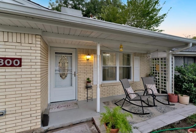 exterior entry at dusk featuring covered porch