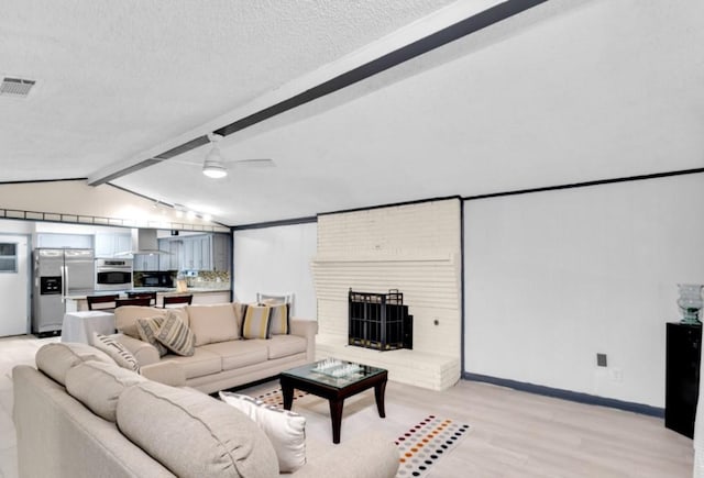 living room featuring ceiling fan, lofted ceiling with beams, a textured ceiling, and light hardwood / wood-style flooring